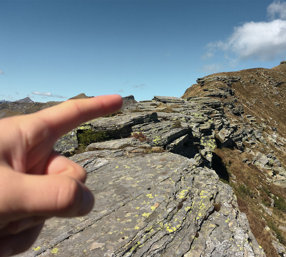 Finger pointing up to the mountains and sky